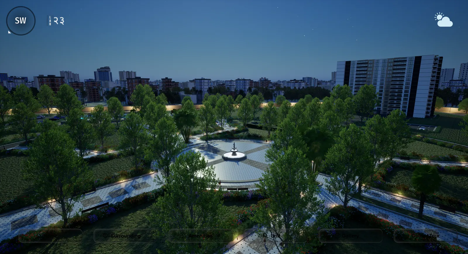 The landscaped park after dark with lit paths, a fountain and planting beds under a deep blue sky